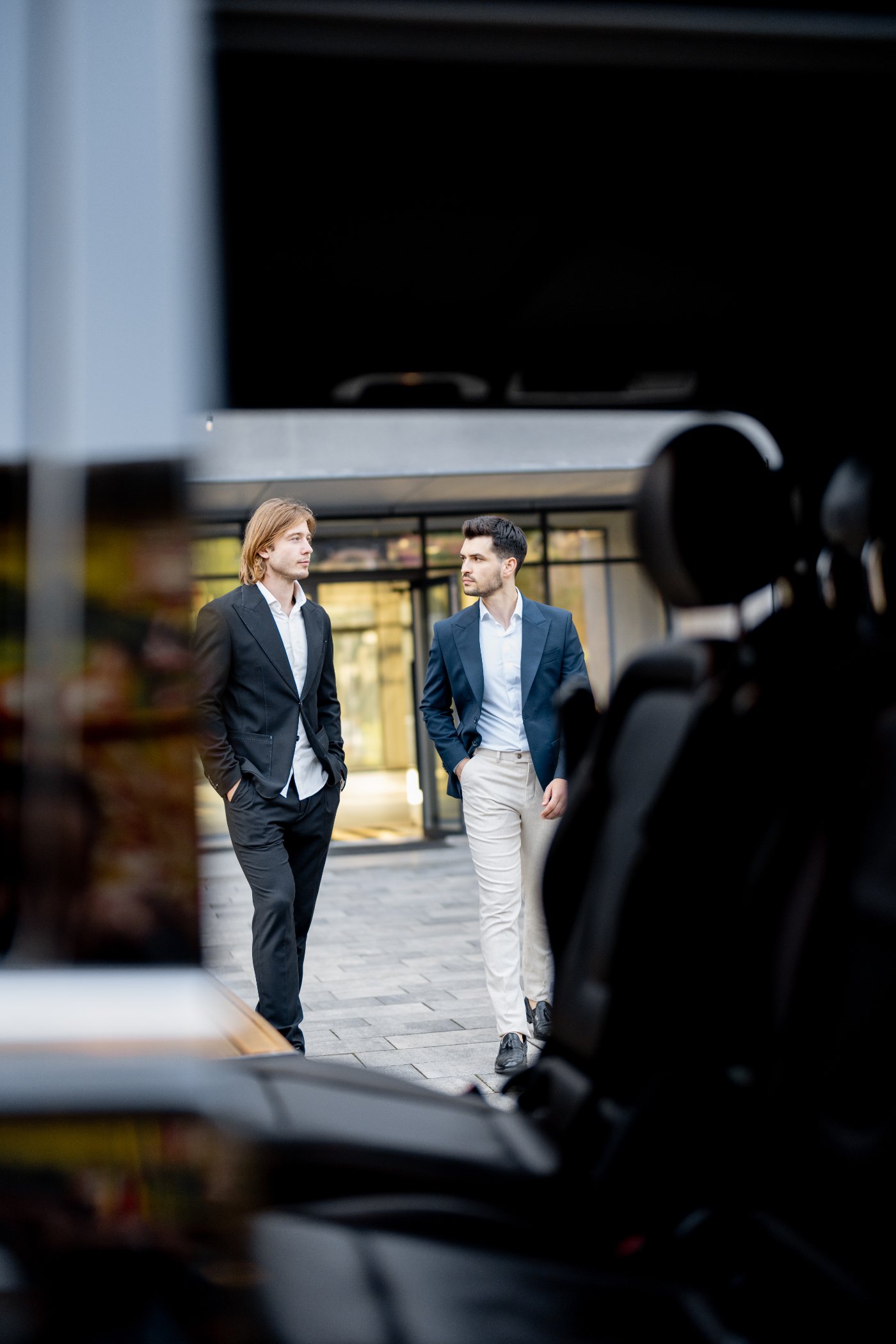 Two executives walking to a waiting car outside an office