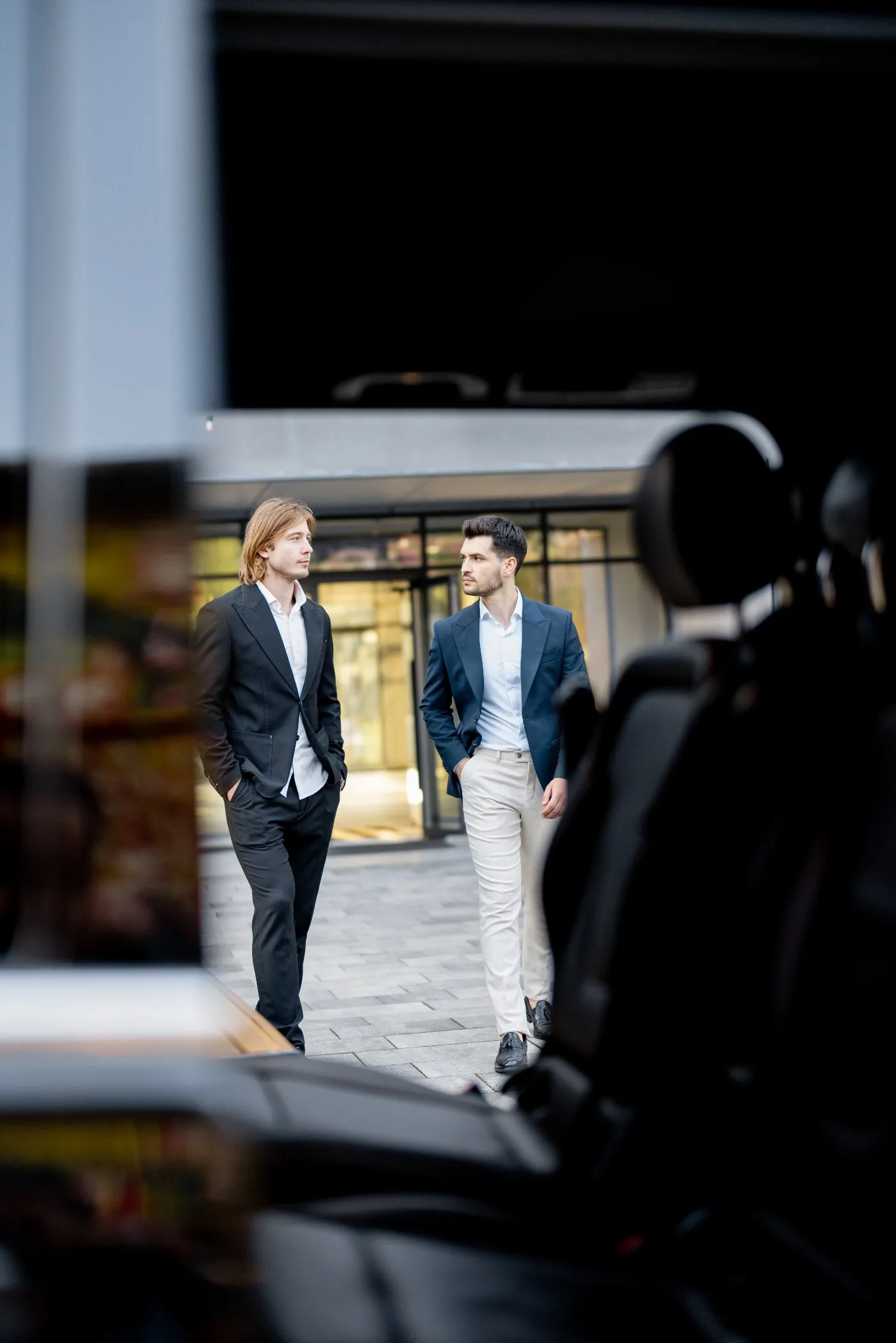 Two executives walking to a waiting car outside an office